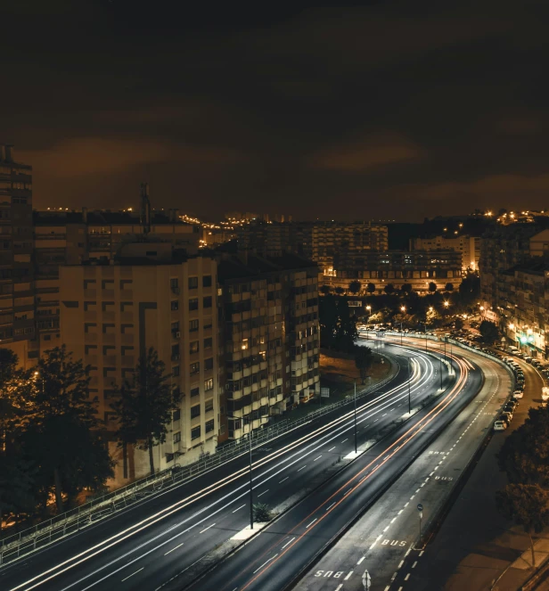 traffic on busy city highway at night with buildings around