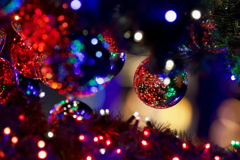 bright christmas balls are strung across a tree