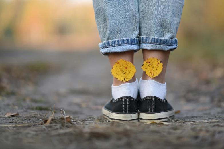 a pair of legs with yellow flower stickers on them