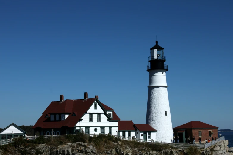 a lighthouse on a mountain with two houses