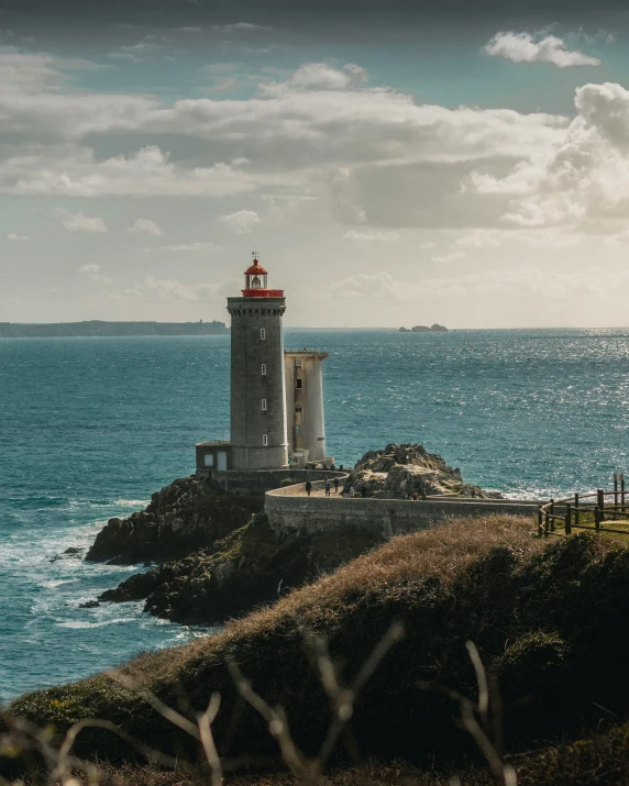 a light house sitting at the end of a cliff next to the ocean