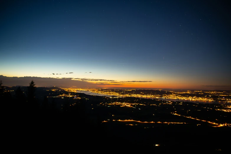 city lights glow on the night sky and hills