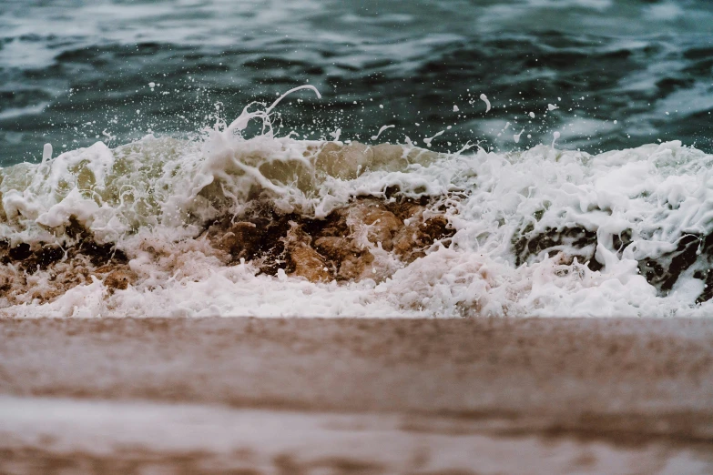 the ocean waves break onto some rocks