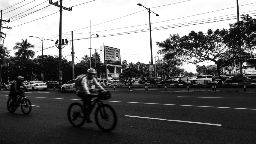 two people riding their bikes through an intersection
