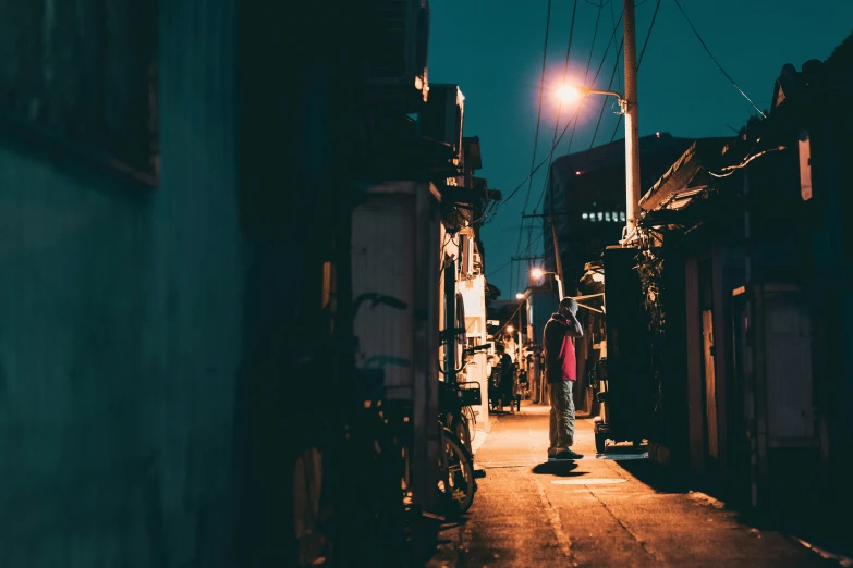 a street with dark buildings and a street lamp