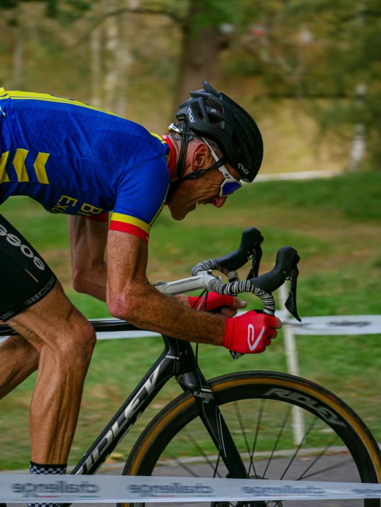 a man riding a bicycle while wearing a blue shirt and red gloves