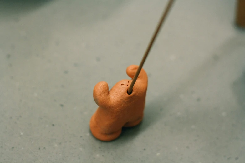 a small bear figurine holds onto the thread