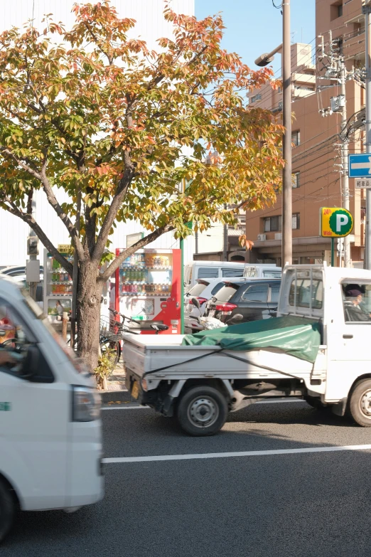 a white truck on street next to a traffic signal