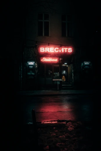 a dark street has a lit up bar sign