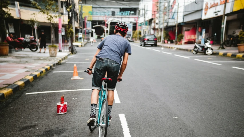 a man riding his bike down the middle of a street