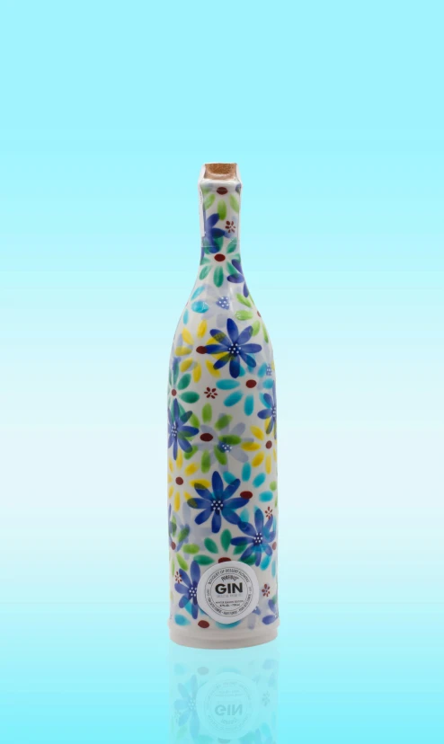 a colorful glass bottle that is sitting on a blue table