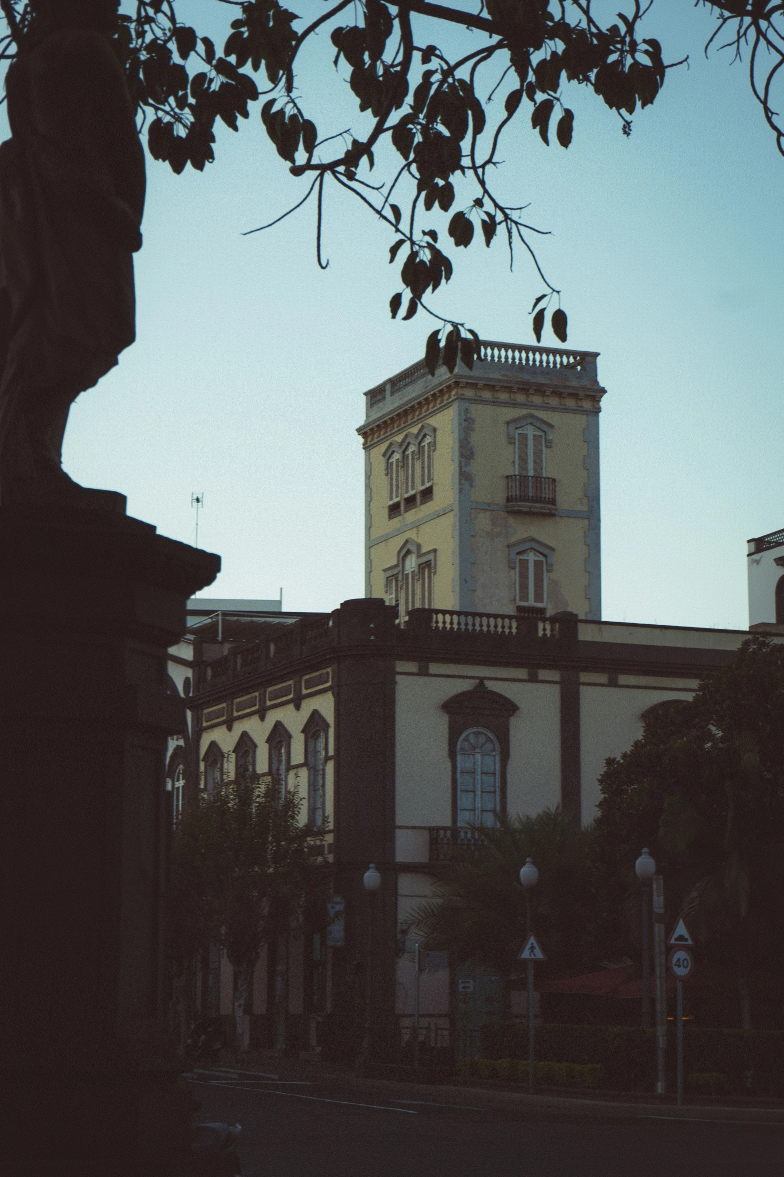 a building sitting in the middle of a street with tall buildings around it