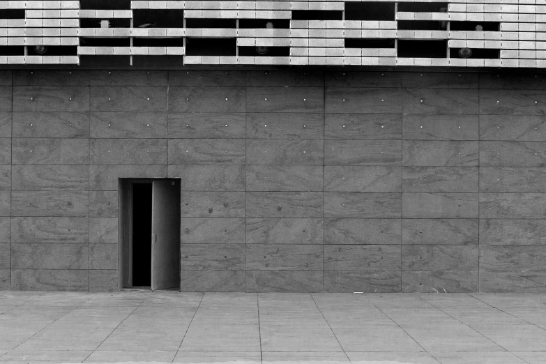 a person with a skateboard walking past a cement wall