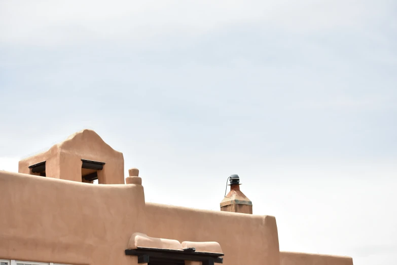 a clock tower that is near an adobe building