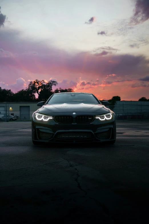 the sunset lights up the bmw on an empty parking lot