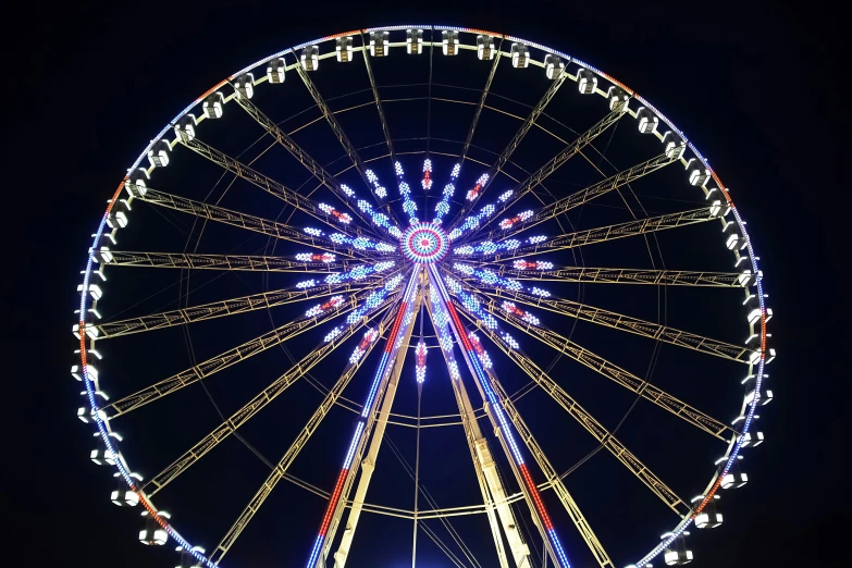 a large ferris wheel illuminated in the night sky