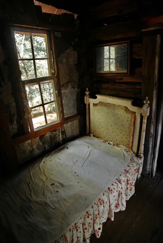 an old bed sits in a rustic room with wood walls
