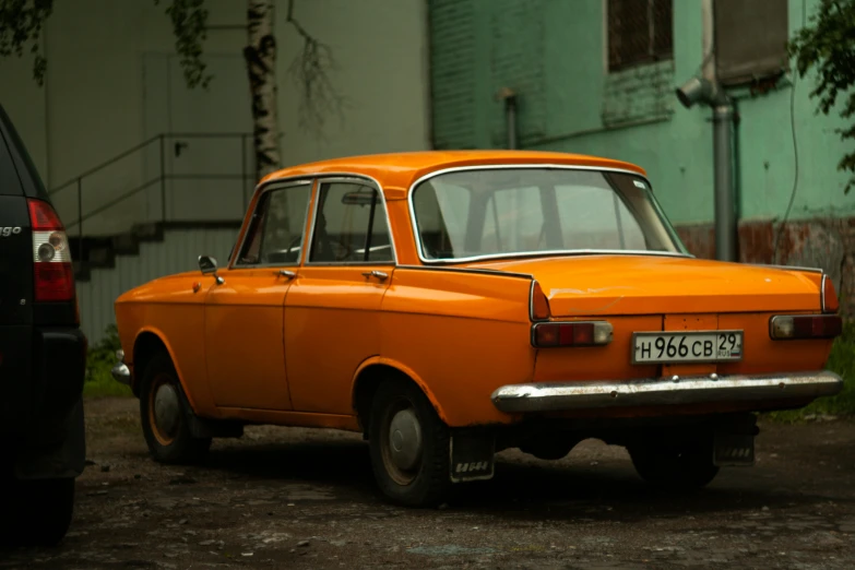 an orange classic car is parked in the street