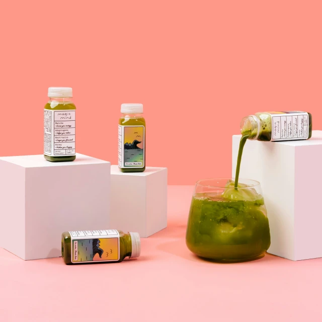 an array of juice in two cups and jars on top of a table