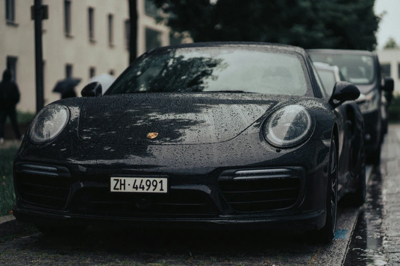 two black porsches parked on the side of the road