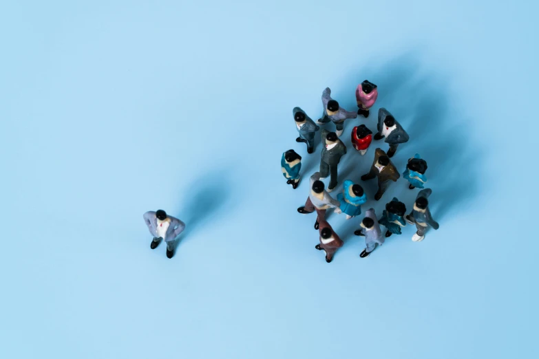 many tiny figurines are placed in a circle on a blue surface