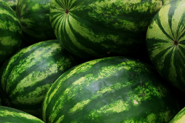 a pile of green and yellow watermelons that are in a pile