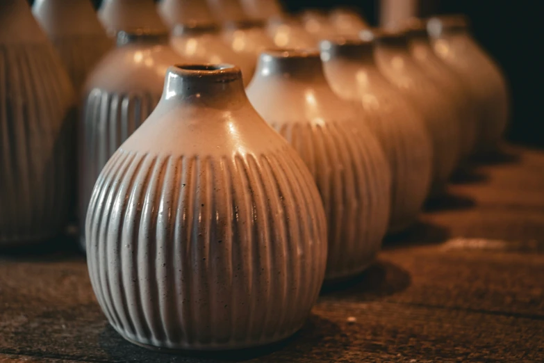 a set of nine white ceramic vases sitting on the ground