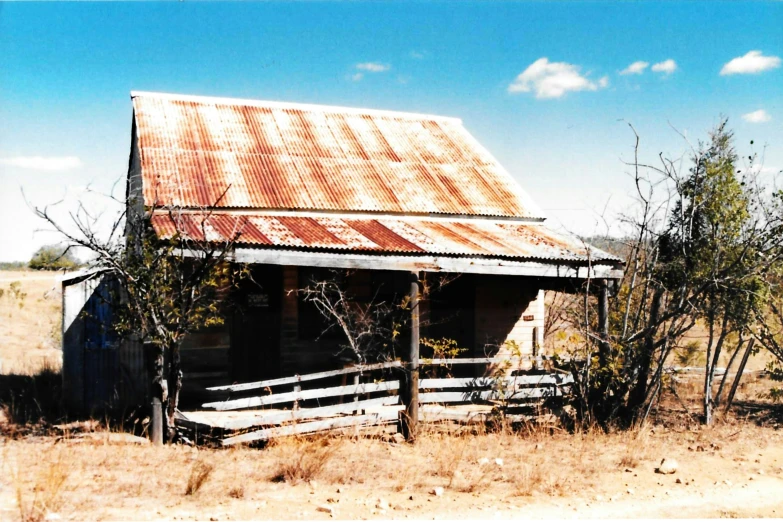 the run down old house sits in an open field