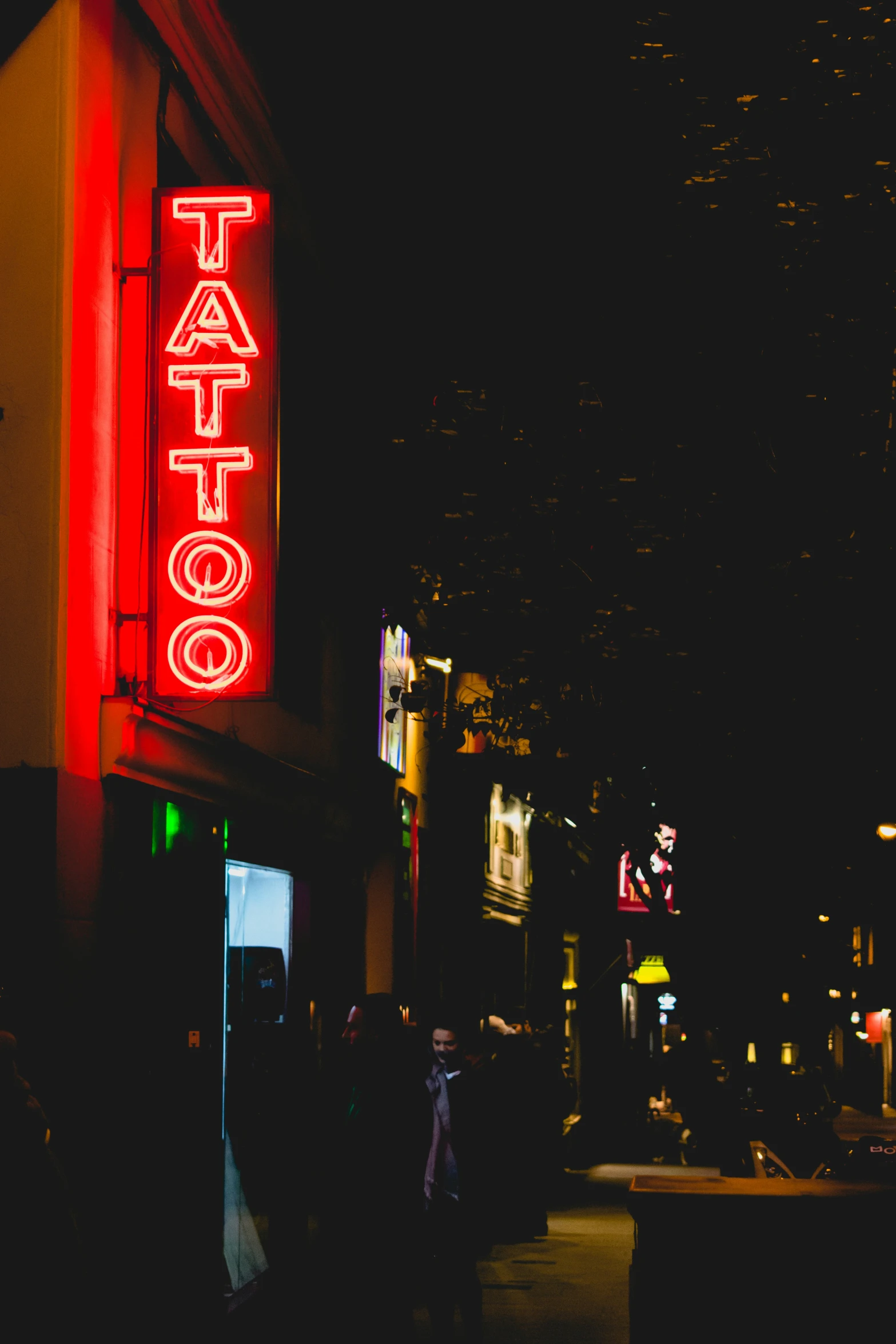 a street at night with a taco restaurant lit up