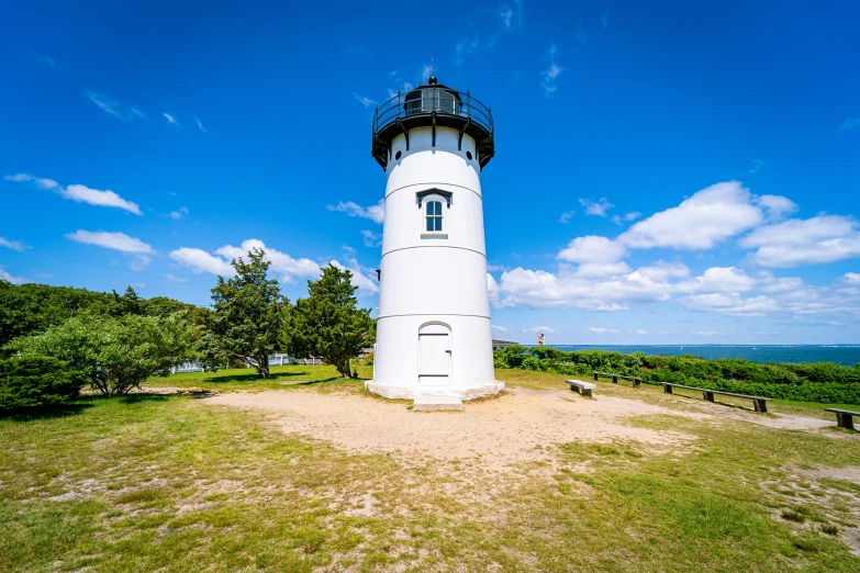 the large light house is perched above the field