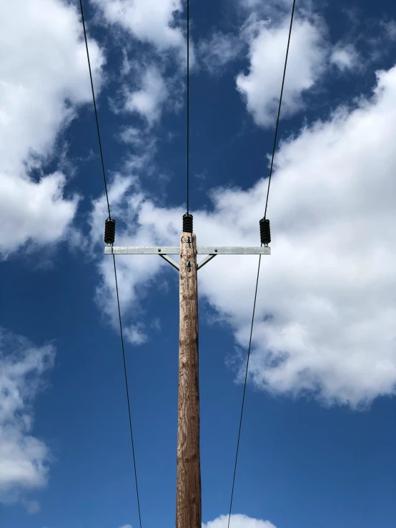 a pole with wires running through it and a sky background