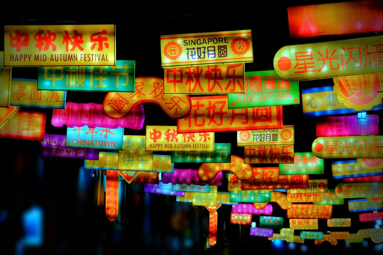 neon signs hanging from a building are lit up