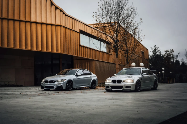 two bmw models parked side by side outside a building