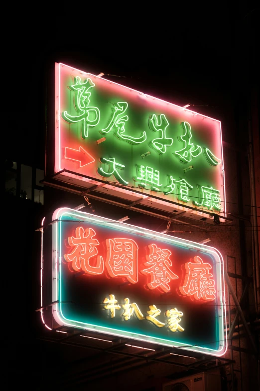 neon signs are lit up in asian writing