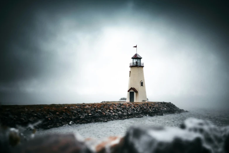 a small white light house standing on the rocks