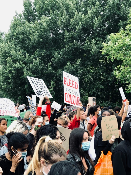 the crowd of people is holding up signs