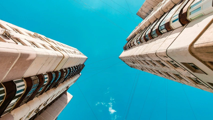 two buildings looking up at the sky from below