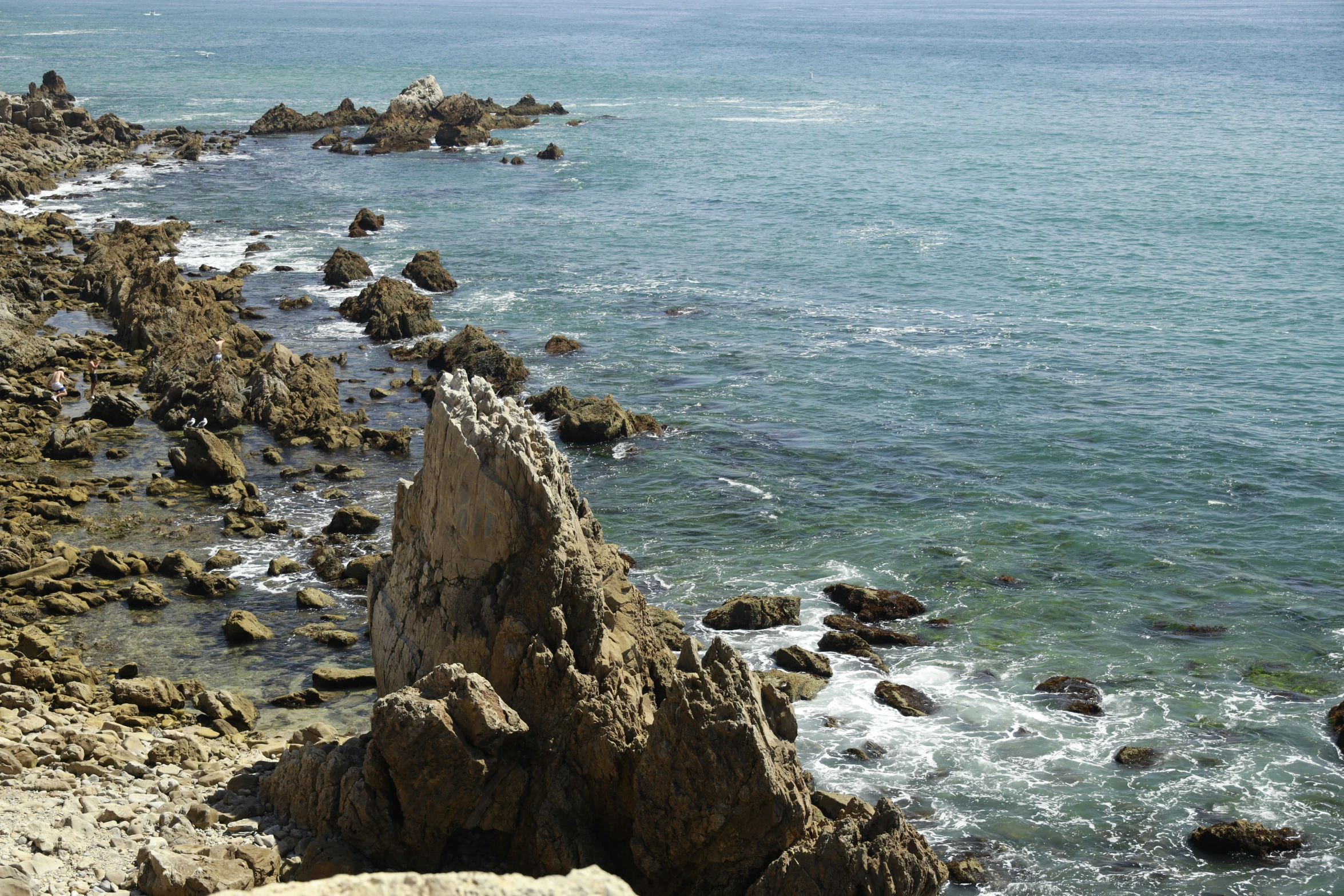 a large body of water sitting next to a rocky shore