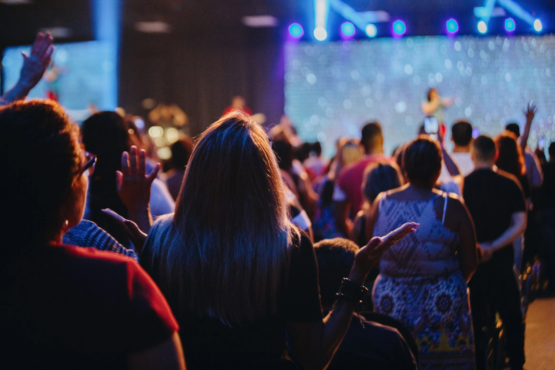 some people are attending an event and there is a large crowd in the background