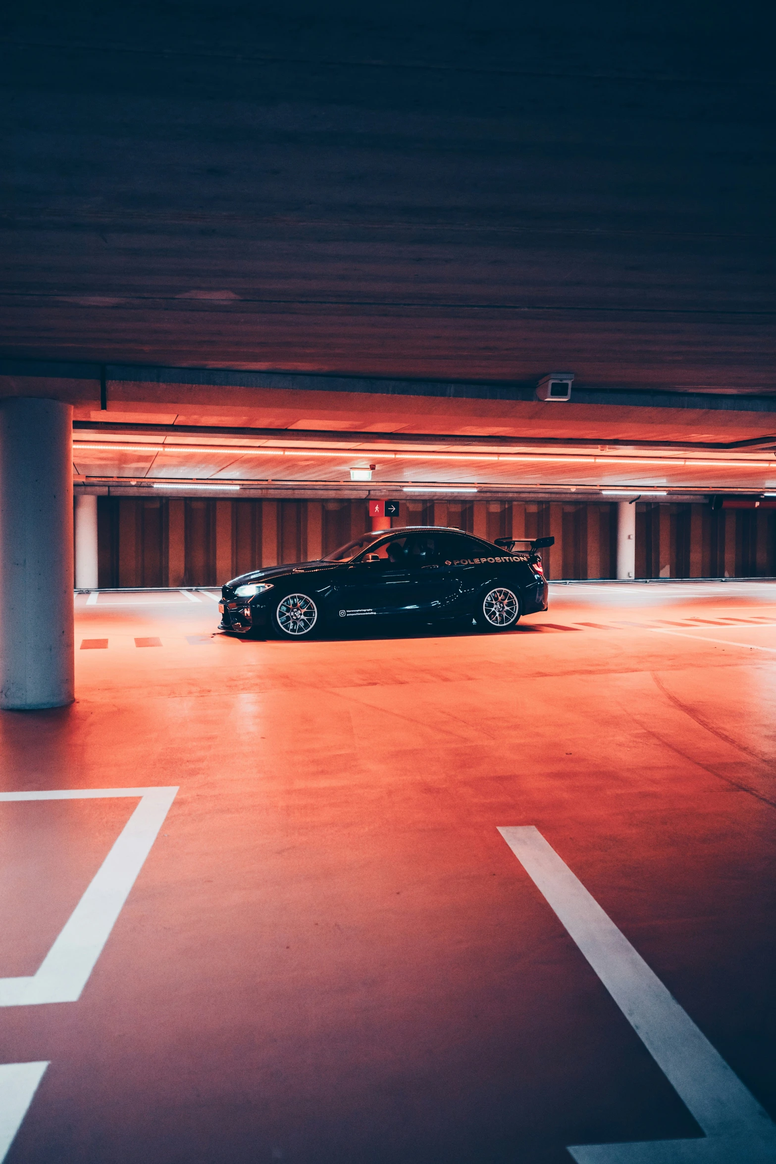 a car in an underground parking space with lights on