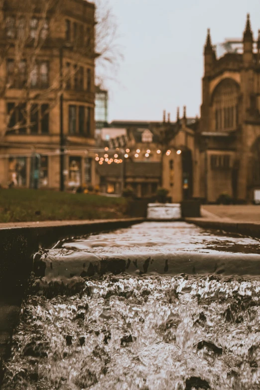 an image of a water fountain in front of buildings