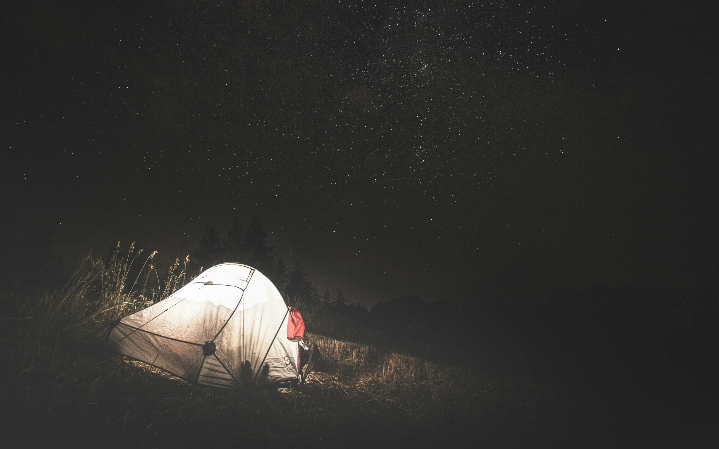 a person sitting at the base of a tent