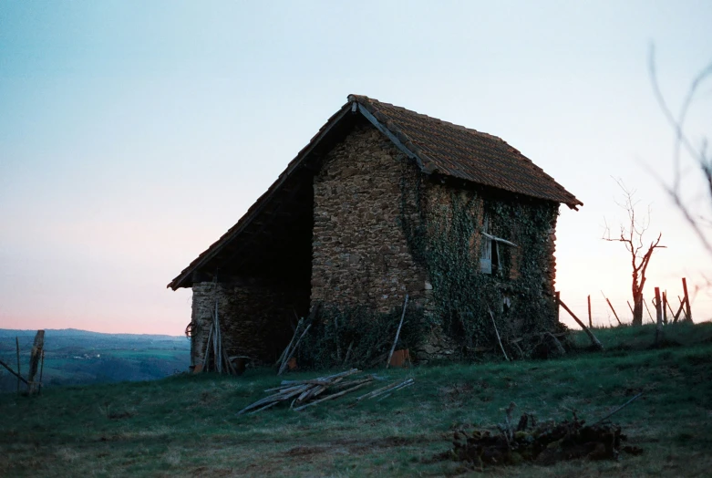 a house sitting in the grass next to a wooden fence