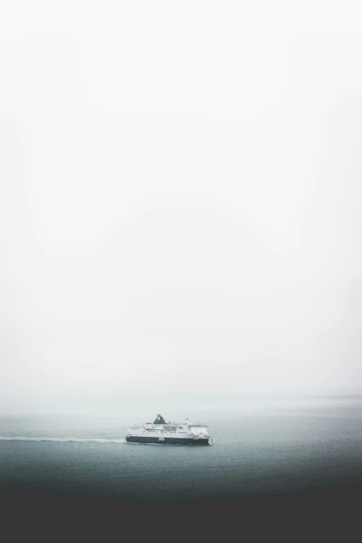 a ship sailing on the ocean in a foggy day