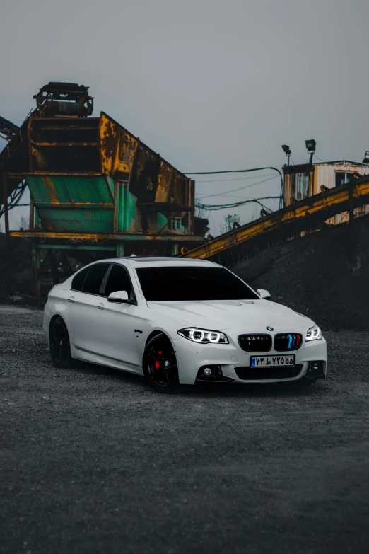 a white car parked in front of a large machine