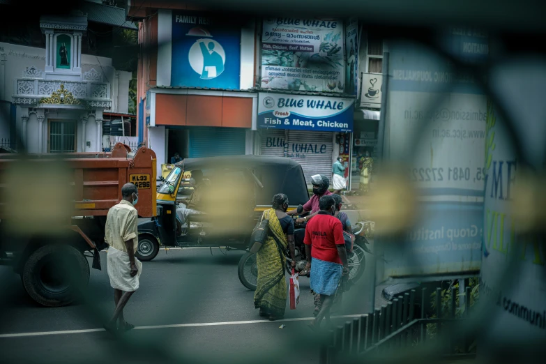 a street scene showing cars and people crossing the street