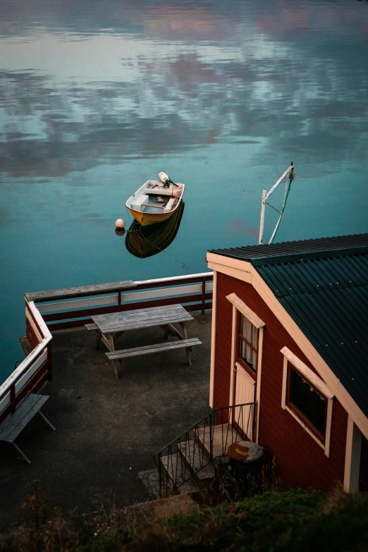 boat on water next to a dock with blue and green water