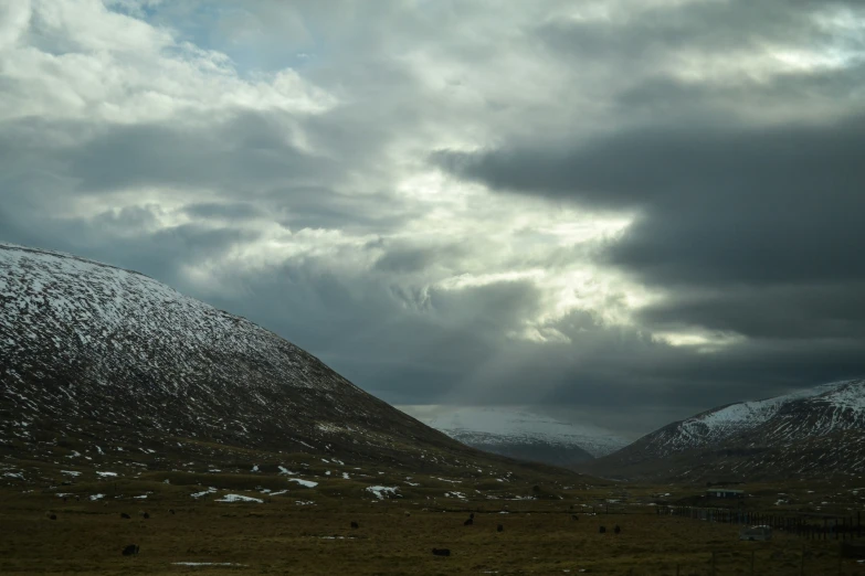 snow covered hills and trees under an overcast sky