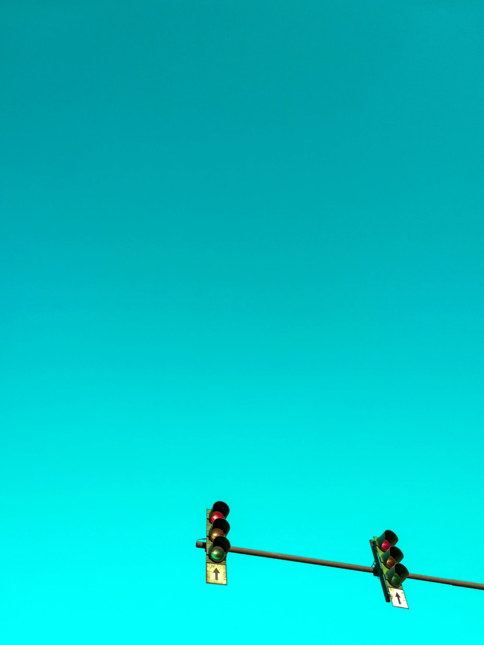 two stop lights in front of a blue sky