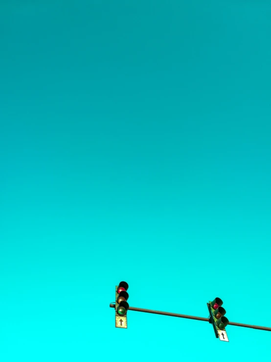 two stop lights in front of a blue sky